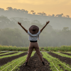 exultant woman in row of crops